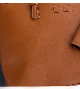 Détail du sac cabas en cuir marron avec gaufrage en forme de cœur et texture de qualité