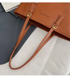 Détail du sac cabas caramel avec texture gaufrée en cœur et boucles dorées réglables