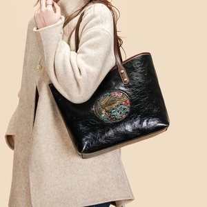 Retro black tote bag with colorful elephant embossed pattern and brown shoulder straps