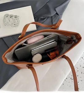 Vue macro de l'intérieur d'un grand sac cabas en cuir marron avec rangement spacieux