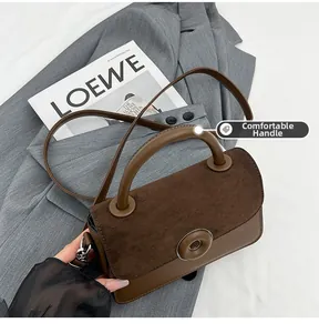 Close-up of the textured matte suede and smooth leather stitching with metal ring buckle