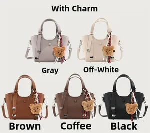 Detailed view of five textured leather handbags with plush bear charms and scarves