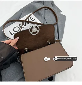 Close-up of brown matte leather crossbody bag with metal magnetic snap closure