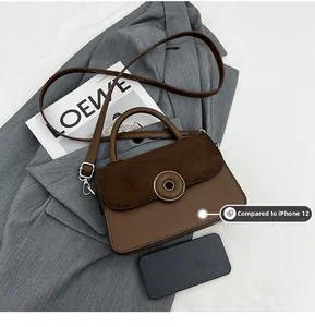 Detailed size comparison of the dark brown mini handbag with an iPhone 12 smartphone