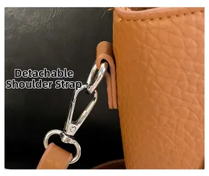 Detail of detachable shoulder strap with silver metal swivel hook on brown leather bag