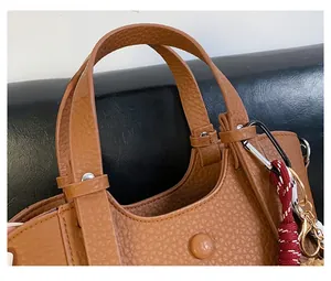 Detail of reinforced handles and metal rivets on a brown pebble leather handbag