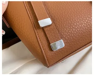 Detailed macro view of the premium litchi grain brown leather with silver metal buckles