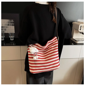 Detailed back view of a red and white striped canvas tote with a cloud plush charm