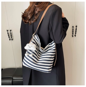 Détail du sac cabas en toile rayée bleue avec bandoulière cuir et charme nuage peluche
