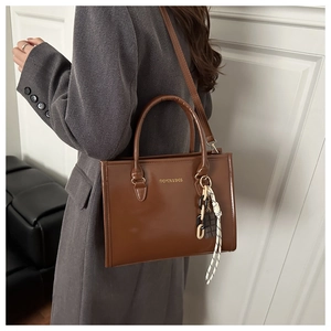 Détail d'un sac cabas vintage marron avec texture cuir brillant et lettrage