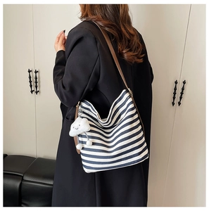 Détail du sac fourre-tout à rayures bleues et blanches avec bandoulière et pendentif nuage