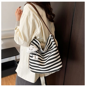 Vue latérale du grand sac cabas rayé en toile avec bandoulière cuir et charme nuage