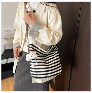 Détail du sac cabas rayé en toile avec charm nuage et bandoulière en cuir brun