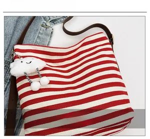 Close-up of red striped canvas tote bag with a cute white cloud plush pendant