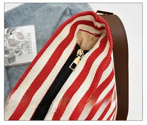 Detail of high-quality zipper closure and striped canvas fabric on the tote bag