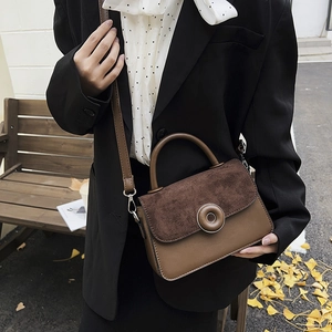 Brown frosted leather tote bag with ring buckle for women on an autumn street