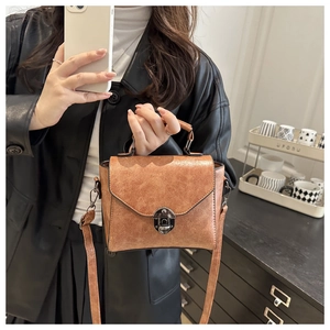 Détail du sac vintage caramel avec fermoir rotatif argent antique et texture rétro chic