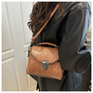 Détail du sac à main vintage marron avec rabat triangulaire et boucle sur une veste en cuir