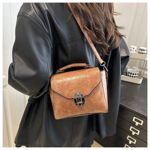 Détail d'un sac bandoulière vintage marron en cuir huilé avec boucle métallique