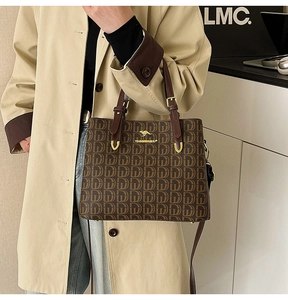 Détail d'un sac cabas marron à motifs géométriques avec logo kangourou doré sur mannequin