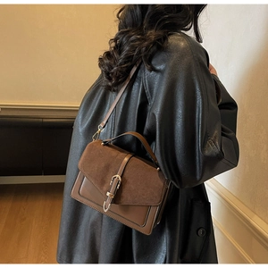 Close-up of vintage brown crossbody bag featuring mixed textures and silver buckle detail