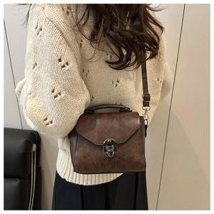Détail d'un sac bandoulière vintage en cuir PU marron avec fermoir métallique chic