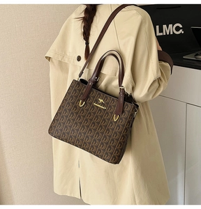 Détail du sac cabas vintage avec motif de lettres et logo kangourou doré sur manteau
