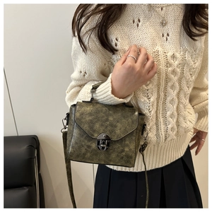 Sac bandoulière en cuir texturé vert rétro porté avec un tricot d'automne style vintage