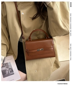 Close-up of caramel leather handbag featuring a gold metal twist lock and sleek handle