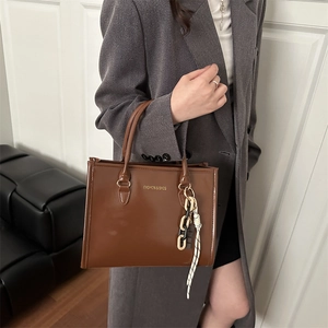 Sac à main en cuir verni marron avec lettrage doré et chaîne décorative tendance
