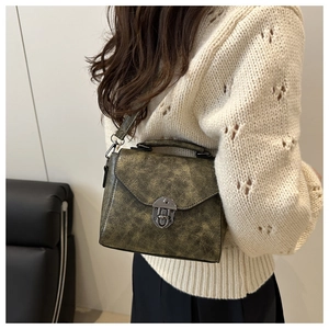 Détail du sac à bandoulière vintage vert olive avec texture vieillie et fermoir métal