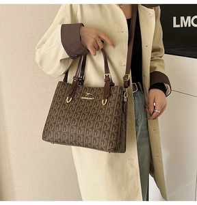 Détail du sac cabas marron à monogramme avec logo kangourou doré et poignées en cuir