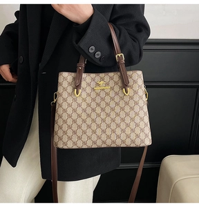 Détail d'un sac cabas monogramme vintage avec lanières en cuir brun et logo doré