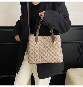 Modèle portant un sac cabas monogramme vintage avec poignées en cuir et logo kangourou doré