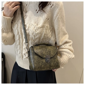 Détail de la texture cuir vintage et du fermoir métallique sur un sac bandoulière chic