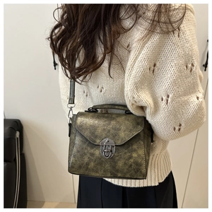 Détail du sac bandoulière vintage montrant la texture cuir vieilli et le fermoir argenté