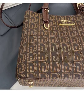 Détail du cabas monogramme marron foncé avec logo kangourou doré et rivets en métal