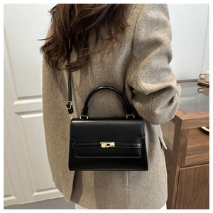 Classic black leather crossbody bag styled with a khaki wool blazer for a chic look