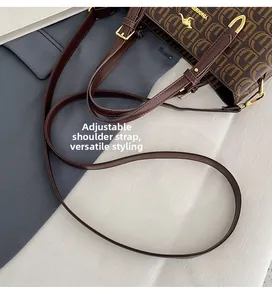 Gros plan du sac cabas marron à monogramme avec logo kangourou doré et bandoulière réglable
