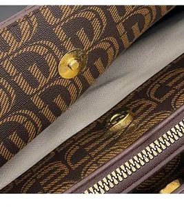 Détail du fermoir magnétique doré et de la fermeture éclair du sac à motif monogramme