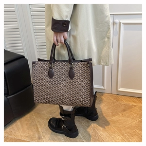 Detail of large tote bag featuring vintage brown honeycomb pattern and sturdy top handles