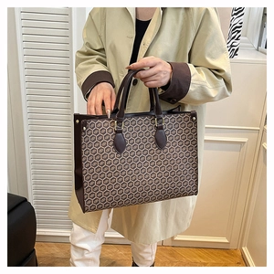 Close-up of vintage tote bag featuring a honeycomb pattern and gold hardware accents