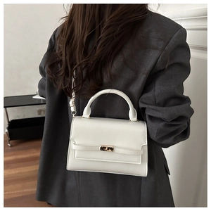 Chic white mini square bag with gold twist lock shown styled with a grey blazer