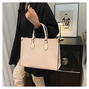 Modern tote bag with vintage honeycomb print and leather handles in a chic room setting