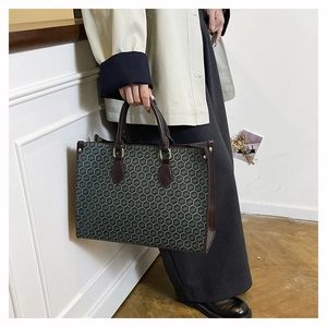 Detailed view of vintage pattern tote bag with leather handles and metallic hardware