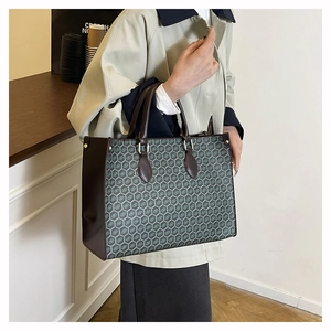 Detail of vintage tote bag featuring geometric honeycomb patterns and leather handles