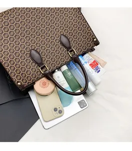 Detail view of large capacity tote bag with geometric print and brown leather handles