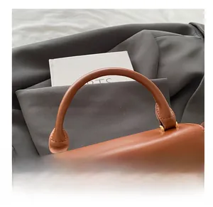 Detail of caramel leather handbag with gold metal clasp and professional stitching