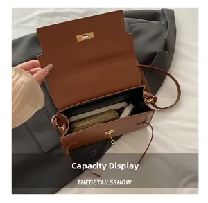 Detail showing the internal storage capacity of the brown crossbody bag with daily items