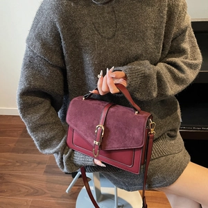 Vintage burgundy crossbody bag with suede patchwork and gold buckle worn by model